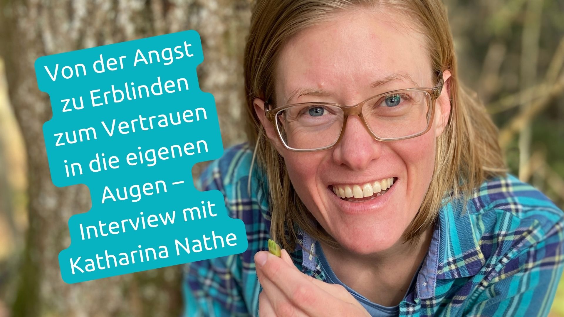 Katharina Nathe hält eine Knospe in der Hand, sitzt vor einem Baum im Wald